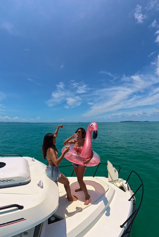 Guests relaxing on a boat with a pink flamingo float