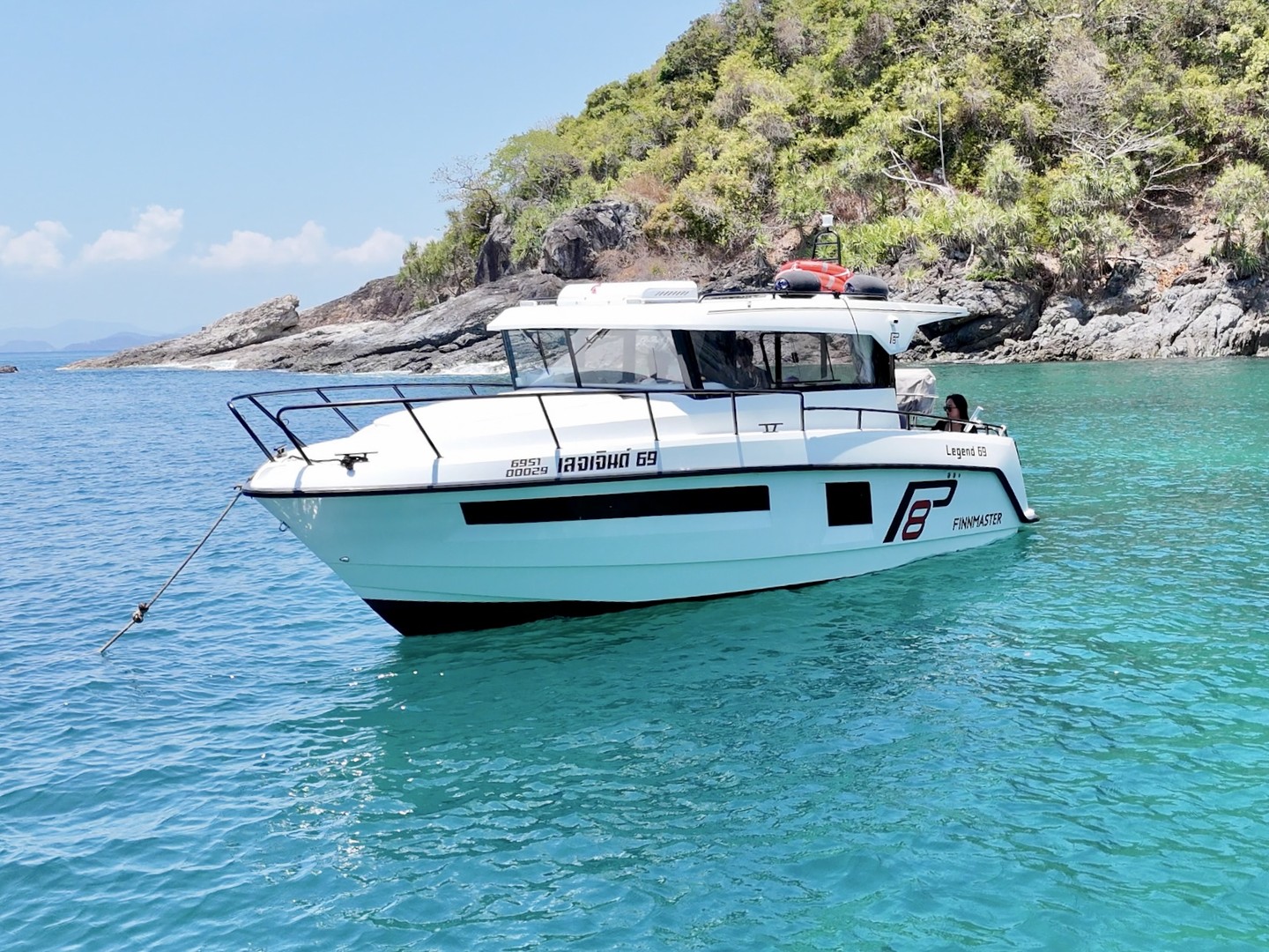 Finnmaster Pilot anchored beside a green island shore