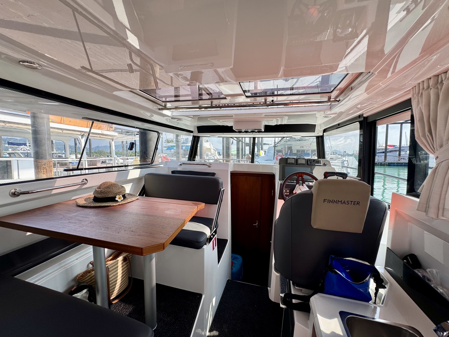 The air-conditioned cabin of the Finnmaster Pilot with a dining table and helm