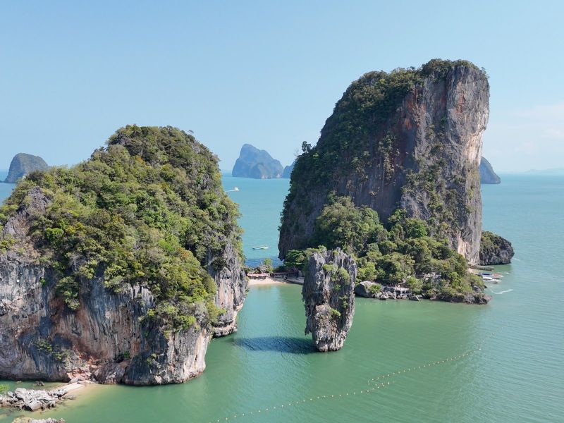 Towering limestone karsts rising from the calm green water of Phang Nga Bay