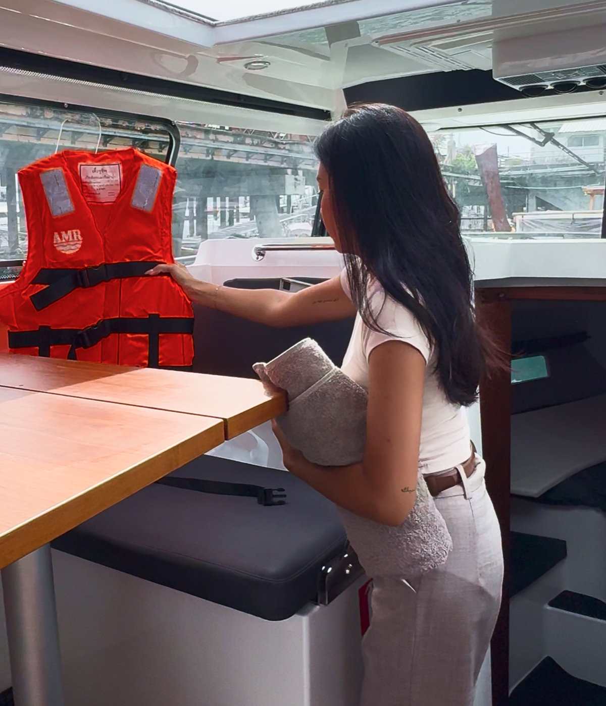 A team member holding a life jacket inside the boat