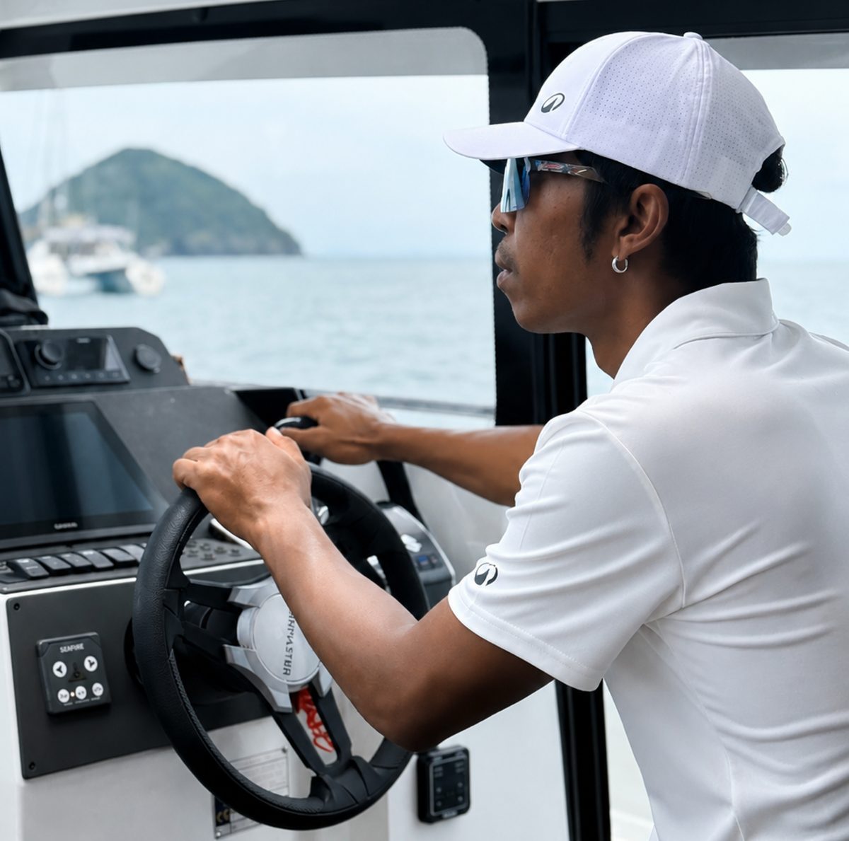 A member of the AquaTour crew at the helm